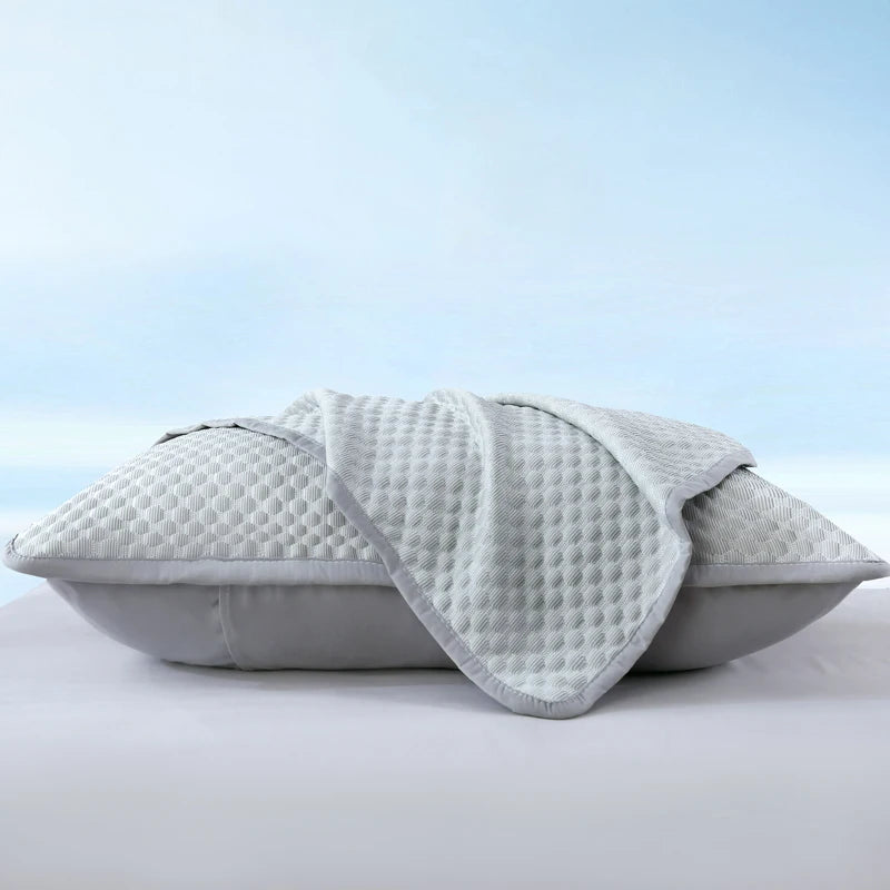 A light gray breathable cooling pillowcase folded and displayed on a white surface.