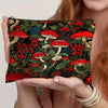 A dark green fabric pouch featuring a dense pattern of red mushrooms and foliage.