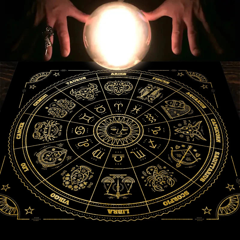 Hands illuminate a mystical zodiac tarot tablecloth with astrological symbols and zodiac signs.
