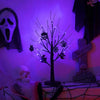 An LED Halloween birch tree decorated with orange and purple lights, set against a dark background.