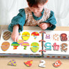 A child is interacting with a Montessori busy book featuring colorful, textured shapes and puzzles.