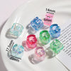 Various sizes and colors of clear and colored acrylic alphabet beads displayed on a white plate.