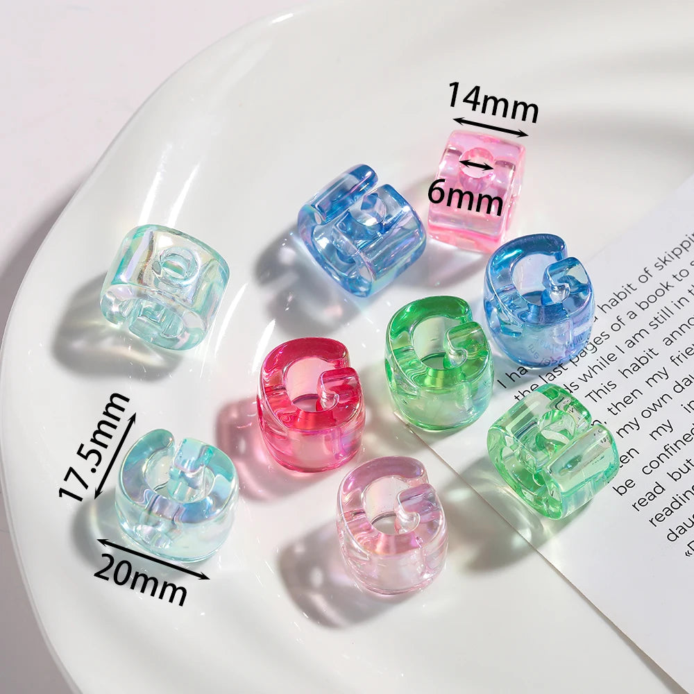 Various sizes and colors of clear and colored acrylic alphabet beads displayed on a white plate.