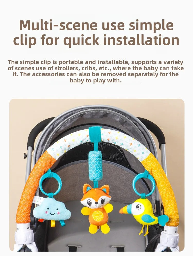 A baby stroller arch toy features colorful hanging plush charms, including a cloud, an fox, and a yellow bird.