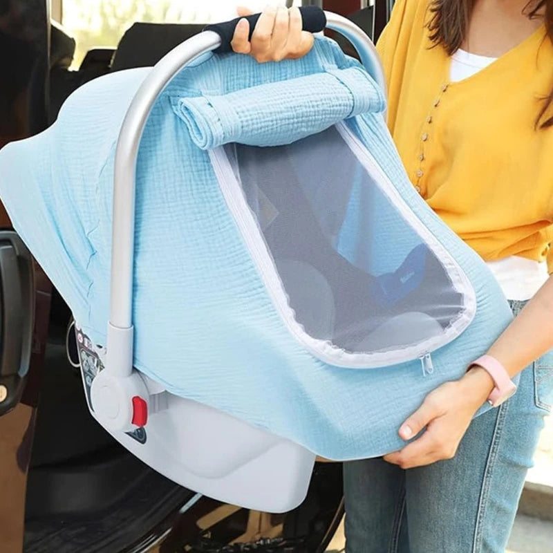 A woman holds a light blue breathable 2-in-1 car seat cover and mosquito net for babies.