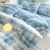 A light blue and white plaid fleece duvet cover with a rabbit design displayed on a bed.