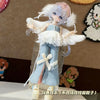 A detailed photograph of a sweet maid dress outfit for a BJD doll, featuring light blue denim overalls and white ruffled wing