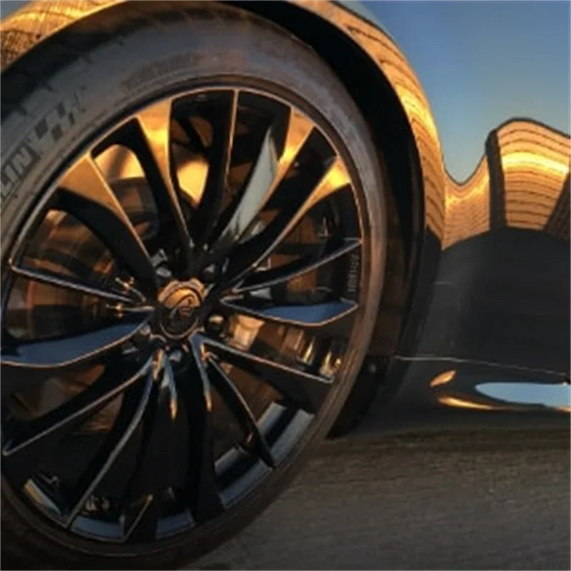 Close-up of a black car wheel with polished spokes and anti-rust protective hub bolt covers.