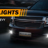 Close-up of an LED fog light assembly installed on a dark colored Chevrolet truck.