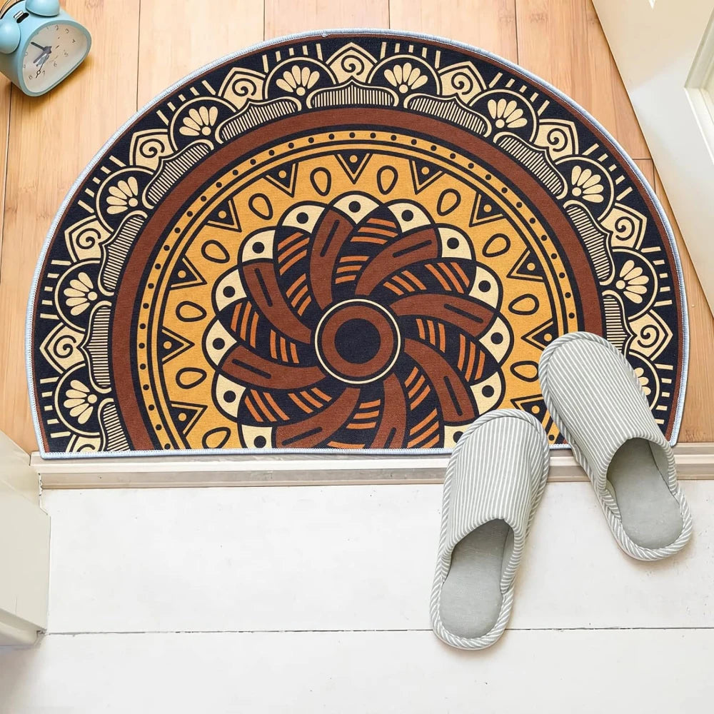 A tribal boho semi-circle doormat with earthy tones and intricate patterns is displayed on a white floor.
