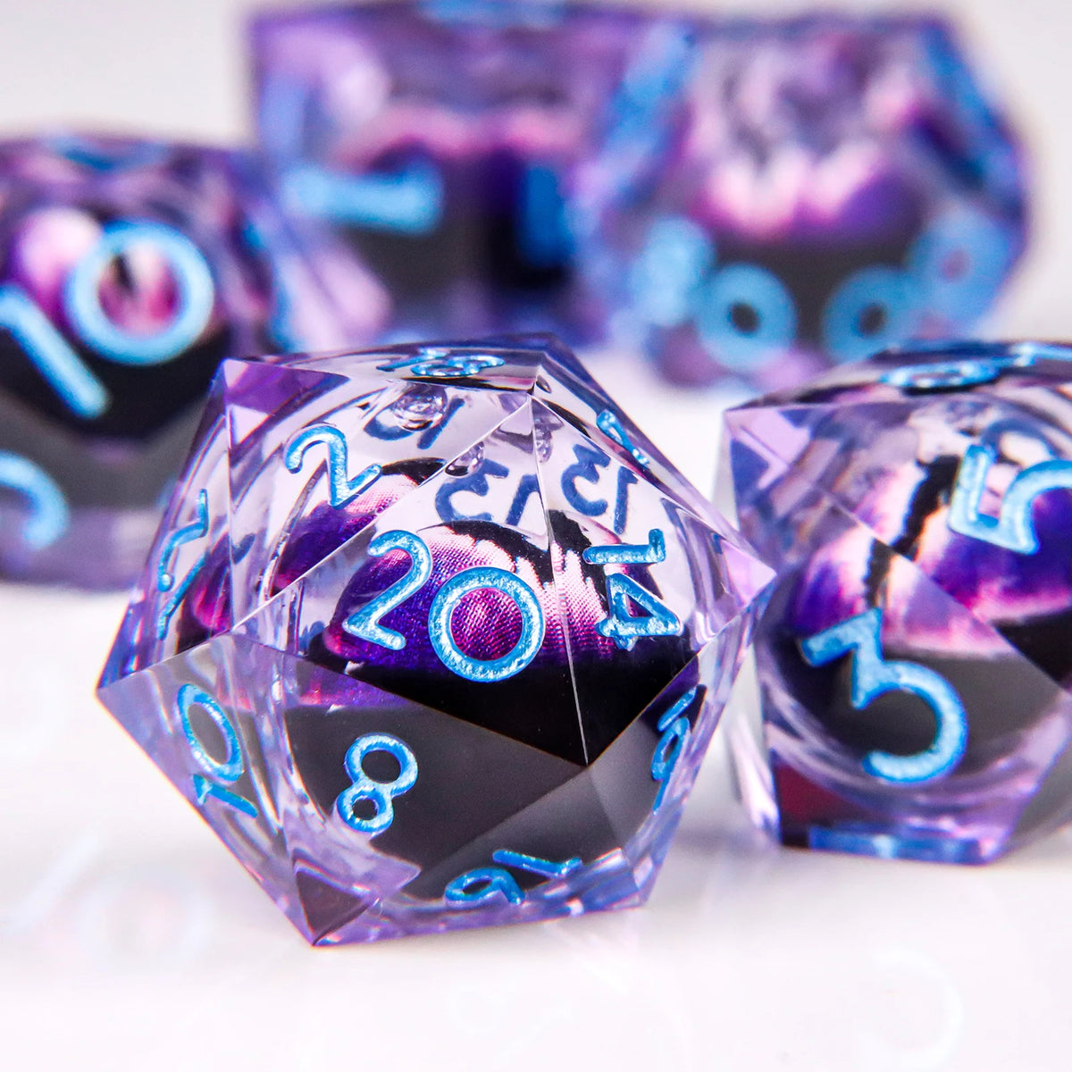A close-up of a set of liquid core resin dice showing purple and blue dragon eye designs.