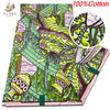 A fabric print featuring green and pink African wax design on a light background.