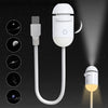 A white 2-in-1 mini projector night light with a USB connector and a light source illuminating a dark background.