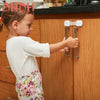 A young girl is adjusting adjustable baby safety locks on a wooden cabinet door.