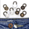 A collection of adjustable metal extender buttons for jeans and trousers displayed on a denim fabric.