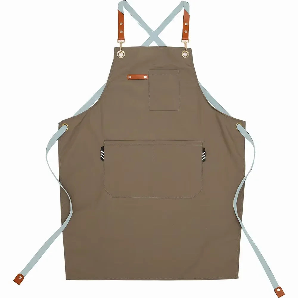 A tan cotton canvas apron with adjustable straps and multiple pockets for kitchen or salon use.