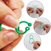 Hands demonstrate how to use reusable green garden plant support clips for tying vines.