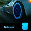 A close-up of a car tire with a glowing blue valve cap, showing the luminous design.