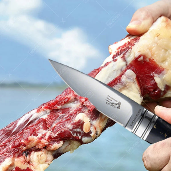 A hand holds a stainless steel chef's cleaver slicing through raw red meat.