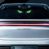 Nahaufnahme des Frontgrills eines Autos mit leuchtend grünen Augen und roten Lichtstreifen.