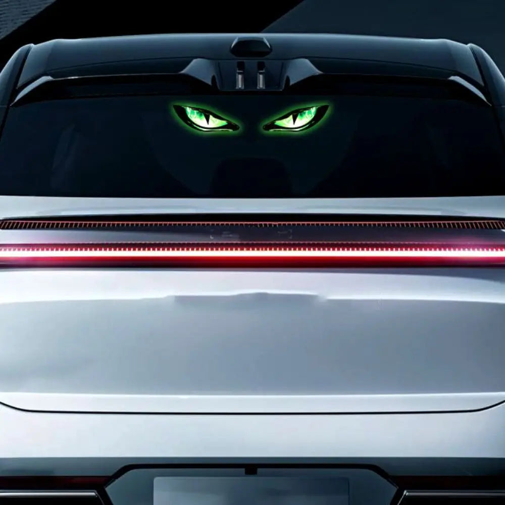 Nahaufnahme des Frontgrills eines Autos mit leuchtend grünen Augen und roten Lichtstreifen.