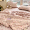 Pink cartoon pattern kids lightweight summer quilt spread on a bed