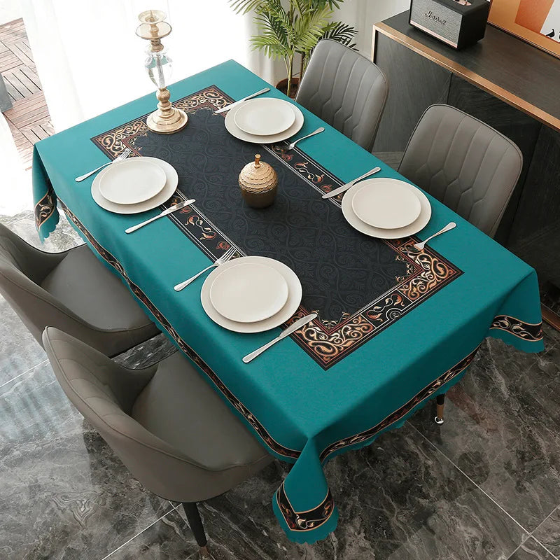 A teal tablecloth set for a formal meal featuring white plates, silverware, and a decorative centerpiece.