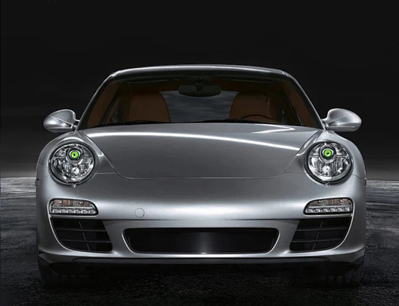 Silver Porsche headlight with a green LED devil eye feature and grille detail.