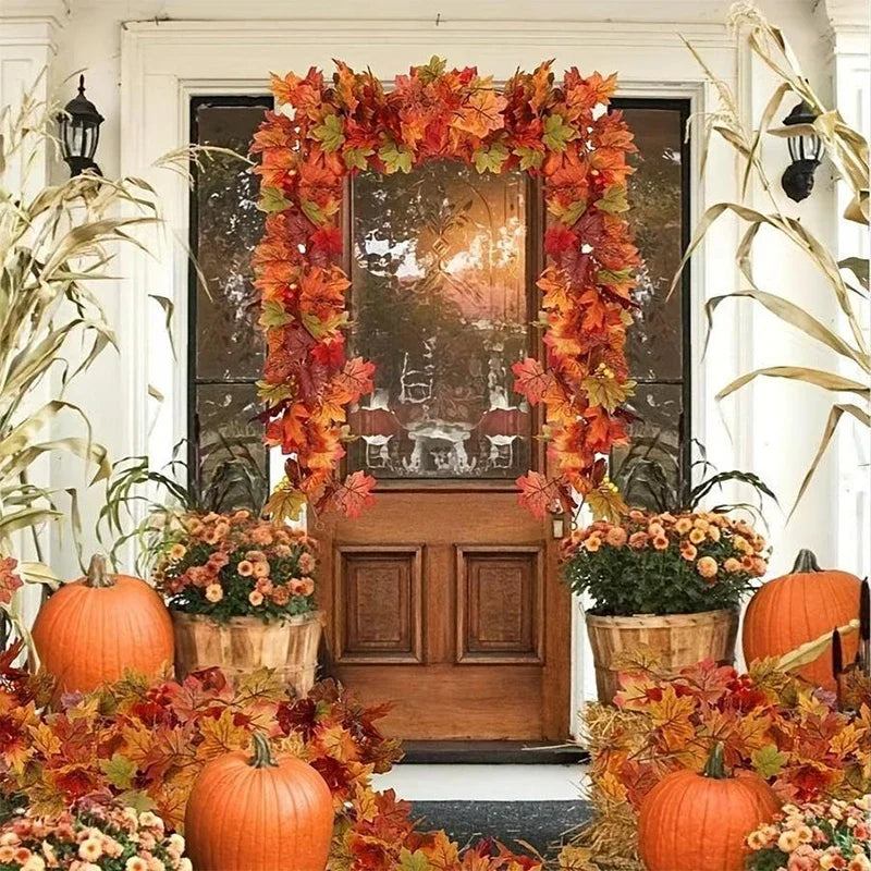 An autumn decor display featuring an artificial maple leaf garland, pumpkins, and fall foliage arranged around a wooden door.