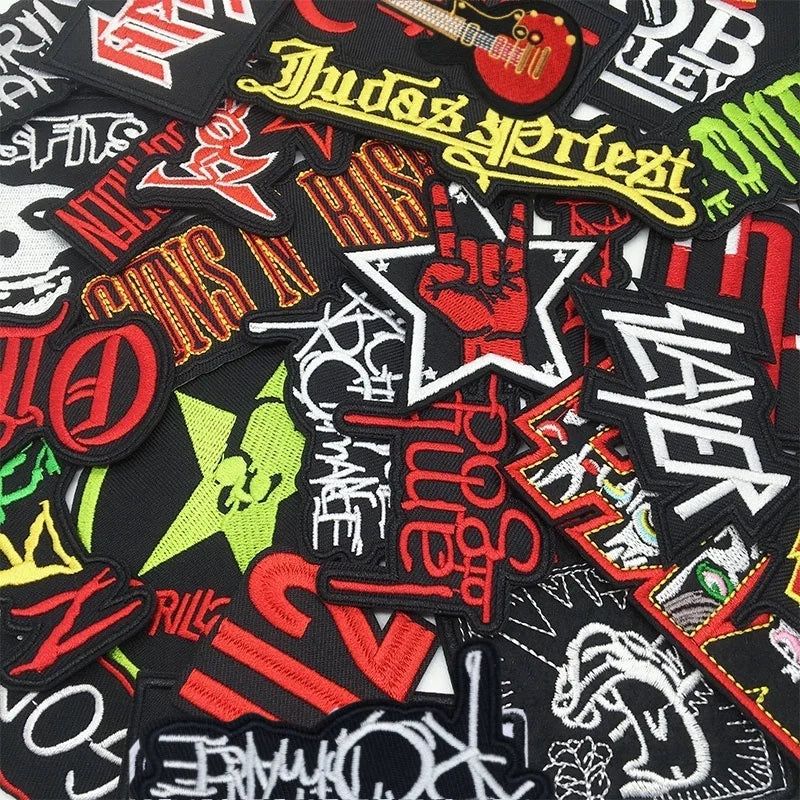 A collection of black and red embroidered iron-on patches featuring various rock band and music-related text and symbols.