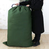 A person holds an extra large heavy-duty canvas laundry bag with a drawstring closure in a dark olive green color.