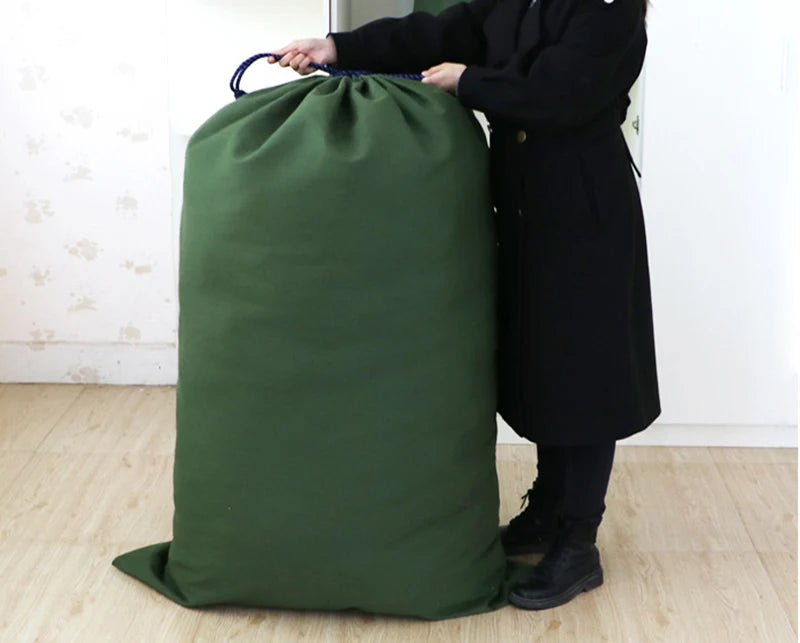 A person holds an extra large heavy-duty canvas laundry bag with a drawstring closure in a dark olive green color.