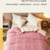 A pink quilted duvet cover and blanket displayed on a bed with white pillows.