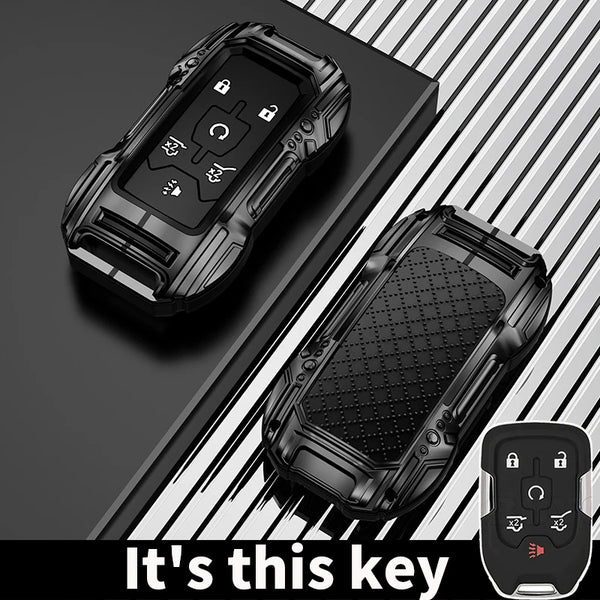A black zinc alloy key fob case for a Chevy Silverado or GMC Sierra truck is shown on a dark surface.