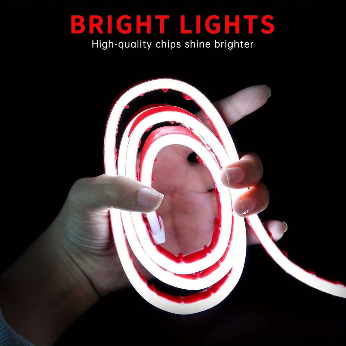 A hand is holding a flexible LED strip light that glows bright red and white in a coiled shape against a dark background.
