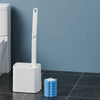 A white disposable toilet cleaning brush kit with an auto-open lid standing next to a blue stack of cleaning discs.