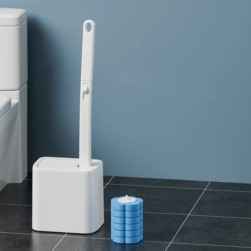 A white disposable toilet cleaning brush kit with an auto-open lid standing next to a blue stack of cleaning discs.
