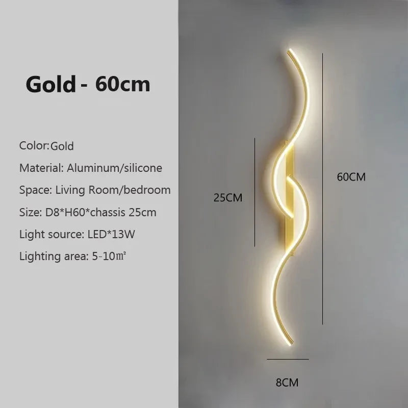 A vertical gold LED wall lamp with a curved design mounted on a light gray wall.