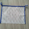 A square mesh silicone bath toy with blue trim and elastic loops for toddlers.