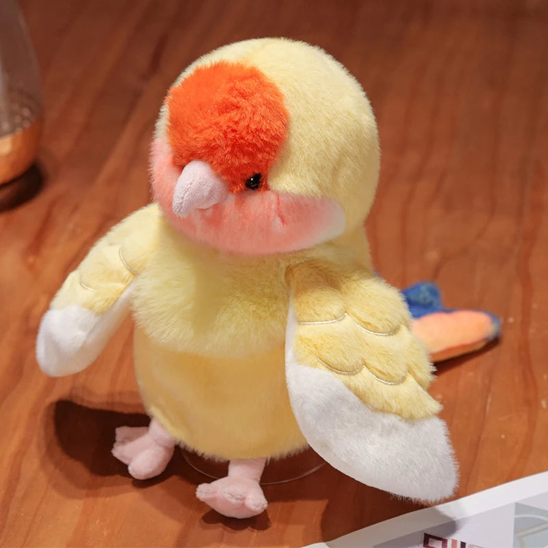 A yellow plush parrot hand puppet toy with orange feathers and pink accents.