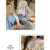 A woman models a cream-colored blouse with lace detailing and long sleeves, paired with blue jeans.