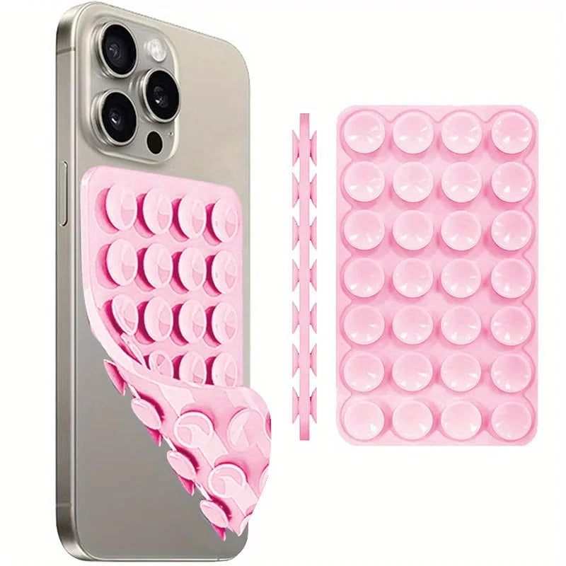 A silver smartphone is shown next to a pink silicone suction cup phone mount with multiple circular pads.