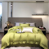 Luxuriöses olivgrünes Bambusbettwäsche-Set auf einem modernen Bett mit neutralem Kopfteil und minimalistischer Beleuchtung.
