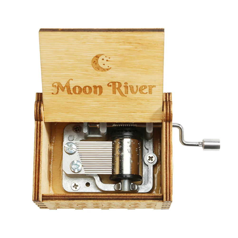 A wooden music box with a light wood casing and an engraved lid featuring the text Moon River.