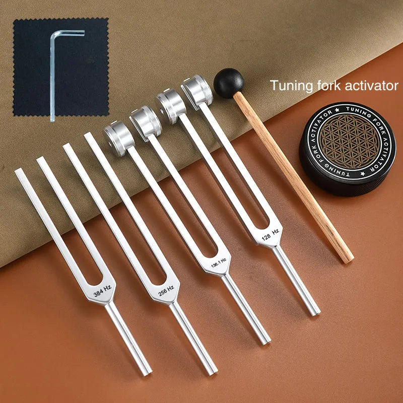 A set of tuning forks with activators showing various frequencies including 128, 136, 256, and 384 Hz placed on a brown surfa