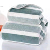 A stack of folded striped bath towels in shades of gray and white.