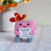 Handmade crochet dumpster fire doll with bright orange and red features sitting on a white surface.