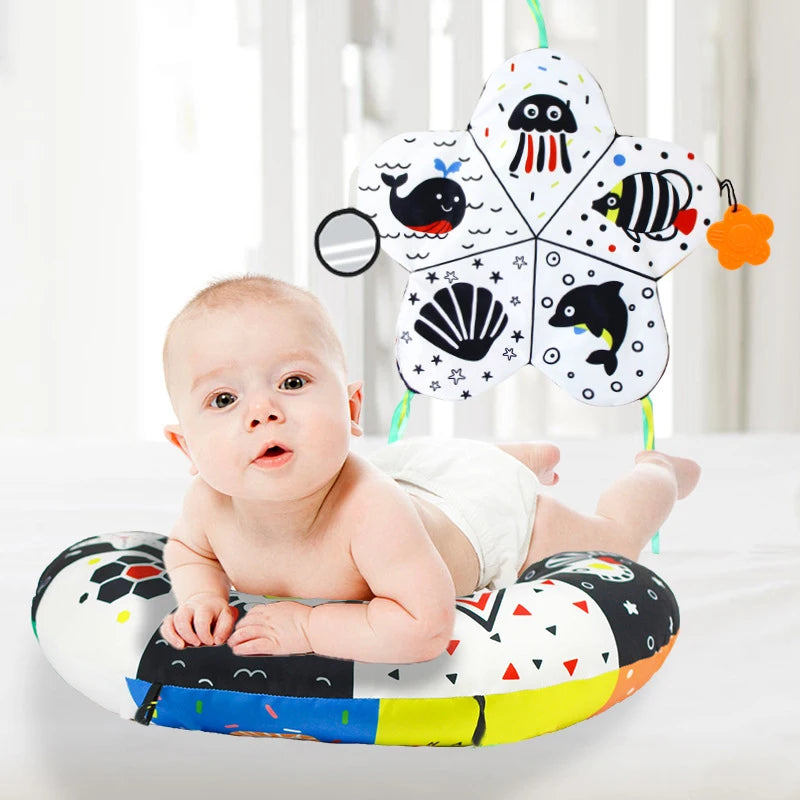 A high contrast tummy time pillow with various sea creatures is shown for a baby.