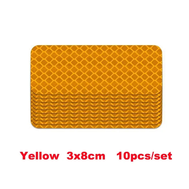 A set of ten yellow 3x8cm high-visibility reflective strip stickers for car safety.
