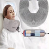 A woman rests her head on a gray cloth-filled U-shaped neck pillow in a white medical setting.